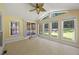 Bright sunroom featuring large windows, a ceiling fan, tile flooring, and access to a back deck at 1005 Enderbury Dr, Raleigh, NC 27614