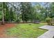 Large backyard featuring mature trees, a trampoline, a fire pit, and a grass lawn at 1006 Mingo Pl, Knightdale, NC 27545