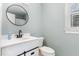 Updated bathroom features a modern vanity with black fixtures, round mirror, and neutral paint at 1006 Mingo Pl, Knightdale, NC 27545