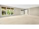 Spacious basement with neutral carpeting, recessed lighting, and large windows overlooking greenery at 1034 Ventnor Pl, Cary, NC 27519