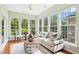 Bright sunroom with hardwood floors, neutral paint, and large windows with wooded views at 1034 Ventnor Pl, Cary, NC 27519