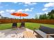 Spacious backyard with a patio, stylish outdoor furniture and a vibrant orange umbrella at 1109 Briar Gate Dr, Holly Springs, NC 27540