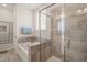 A modern bathroom features a glass shower, soaking tub, and tile floors at 1109 Briar Gate Dr, Holly Springs, NC 27540