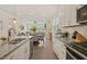 Modern kitchen features granite counters, white cabinets, stainless appliances and is open to the living room at 1109 Briar Gate Dr, Holly Springs, NC 27540