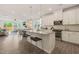 A bright open-concept kitchen features granite counters, an island with seating, and stainless steel appliances at 1109 Briar Gate Dr, Holly Springs, NC 27540