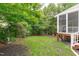 Grassy backyard with a partial view of a screened in porch at 111 Revere Forest Ct, Cary, NC 27519