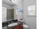 Bathroom featuring black granite countertop and vanity, tile shower, and natural light at 111 Revere Forest Ct, Cary, NC 27519