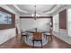 Elegant dining room with wainscoting, a modern chandelier, and hardwood floors, ideal for formal gatherings at 111 Revere Forest Ct, Cary, NC 27519