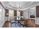 Elegant dining room view showcasing the doorway, wainscoting, a modern chandelier, and hardwood floors at 111 Revere Forest Ct, Cary, NC 27519