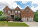Charming two-story brick home with a well-manicured lawn, two-car garage, and classic architectural details at 111 Revere Forest Ct, Cary, NC 27519
