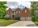 Charming two-story brick home with a well-manicured lawn, two-car garage, and classic architectural details at 111 Revere Forest Ct, Cary, NC 27519