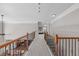 Upstairs hallway with wood railing and iron spindles and neutral wall and carpet colors at 111 Revere Forest Ct, Cary, NC 27519
