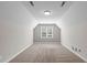 Spacious finished attic featuring neutral walls and carpet, plus a window for plenty of light at 1111 Barrow Nook Ct, Apex, NC 27502