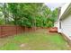 Fenced backyard featuring a green lawn, mature trees and private deck at 1111 Barrow Nook Ct, Apex, NC 27502