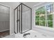 Bathroom featuring a glass shower, soaking tub, and a large window with natural light at 1111 Barrow Nook Ct, Apex, NC 27502