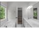 Bright bathroom featuring a soaking tub with jets, a double sink vanity and a view to the bedroom at 1111 Barrow Nook Ct, Apex, NC 27502