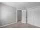 An empty bedroom with neutral walls and carpet features a double-door closet and single door at 1111 Barrow Nook Ct, Apex, NC 27502