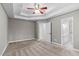Bedroom featuring a tray ceiling, carpet flooring, and an attached bathroom at 1111 Barrow Nook Ct, Apex, NC 27502