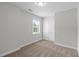 An empty bedroom with neutral walls and carpet features a double-door closet and a window for natural light at 1111 Barrow Nook Ct, Apex, NC 27502