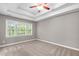 Bedroom with a tray ceiling, carpet flooring, and a large window with natural light at 1111 Barrow Nook Ct, Apex, NC 27502