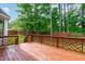 Back porch with wooden deck and patterned railing and large trees in background at 1111 Barrow Nook Ct, Apex, NC 27502
