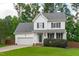 Two-story traditional home with a manicured front lawn and attached garage at 1111 Barrow Nook Ct, Apex, NC 27502