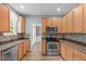 Well-lit kitchen featuring stainless steel appliances, granite countertops, and decorative backsplash at 1111 Barrow Nook Ct, Apex, NC 27502