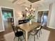 Bright dining room with wooden table, black chairs, and elegant chandelier at 1113 Bexley Hills Bend Bnd, Apex, NC 27502