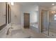 Primary bathroom with a glass shower and a bathtub, double sinks, tile floors, and a walk in closet at 1113 Dartford Green Pl, Wake Forest, NC 27587