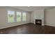 Bright living room with wood-look flooring, large windows, and a cozy fireplace at 1113 Dartford Green Pl, Wake Forest, NC 27587
