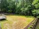 Large grassy backyard featuring mature trees and partial fencing for added privacy at 114 Council Gap Ct, Cary, NC 27513