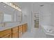 Bathroom featuring double vanity, wooden cabinets, and a soaking tub at 114 Council Gap Ct, Cary, NC 27513