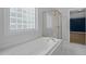 Bathroom showcasing soaking tub, glass block window, and shower at 114 Council Gap Ct, Cary, NC 27513