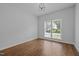 Simple bedroom with hardwood floors and a large window offering natural light and backyard views at 114 Council Gap Ct, Cary, NC 27513