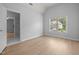 Bright bedroom with LVP flooring, neutral walls, a window, and a doorway to the bathroom at 114 Council Gap Ct, Cary, NC 27513