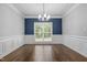 Formal dining room with hardwood floors, wainscoting, and a contemporary chandelier fixture at 114 Council Gap Ct, Cary, NC 27513