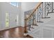 Elegant foyer with hardwood floors, a staircase with wrought iron spindles, and lots of natural light at 114 Council Gap Ct, Cary, NC 27513