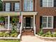 Charming front entrance with brick steps, black door, and lush landscaping at 114 Council Gap Ct, Cary, NC 27513