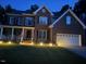 Traditional two-story brick home with an attached two-car garage and a well-manicured lawn at dusk at 114 Council Gap Ct, Cary, NC 27513