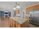 Open-concept kitchen with island, stainless steel appliances, and seamless flow to the living area at 114 Council Gap Ct, Cary, NC 27513
