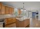Open kitchen with granite countertops, island, and hardwood flooring connecting to living space at 114 Council Gap Ct, Cary, NC 27513