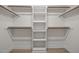 Bright walk-in closet featuring custom shelving and wooden rods for optimal storage solutions at 114 Council Gap Ct, Cary, NC 27513