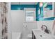 Clean bathroom features white tile walls, a white sink, and modern fixtures at 1209 Edgevale Rd, Durham, NC 27701