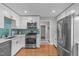 Modern kitchen with stainless steel appliances, white cabinets, and eye-catching backsplash at 1209 Edgevale Rd, Durham, NC 27701