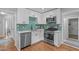 Well-equipped kitchen featuring stainless appliances, modern backsplash, and bright white cabinets at 1209 Edgevale Rd, Durham, NC 27701