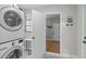 Well-lit laundry room with stacked washer and dryer and access to other rooms at 1209 Edgevale Rd, Durham, NC 27701