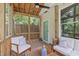 Outdoor screened porch with seating area, ceiling fan, and wooded backyard at 1209 Edgevale Rd, Durham, NC 27701