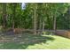 Lush, green backyard with a wooden fence and mature trees, offering plenty of space for outdoor activities at 12320 Tetons Ct, Durham, NC 27703