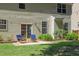 Inviting patio with comfortable blue chairs and lush landscaping, perfect for outdoor relaxation and entertaining at 12320 Tetons Ct, Durham, NC 27703