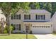 Two-story home with tan siding, black shutters, well-kept lawn, and mature trees at 12320 Tetons Ct, Durham, NC 27703